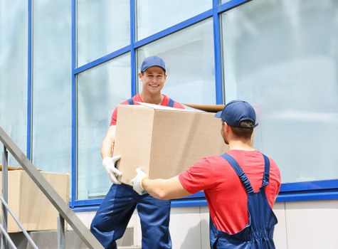 Local removalists carrying furniture through a typical South London home entrance