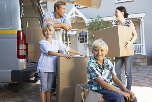 Careful loading of household items into a moving van with straps and blankets